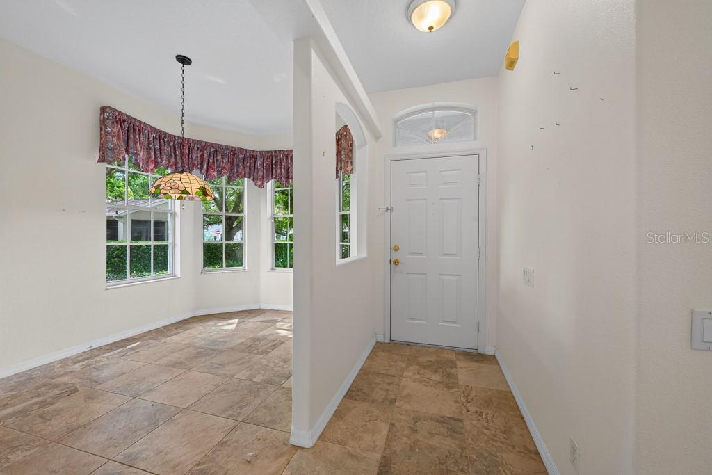 An entryway with tile flooring leads to a dining nook with a bay window — 4355 BURNBERRY GLEN COURT, SPRING HILL, FL