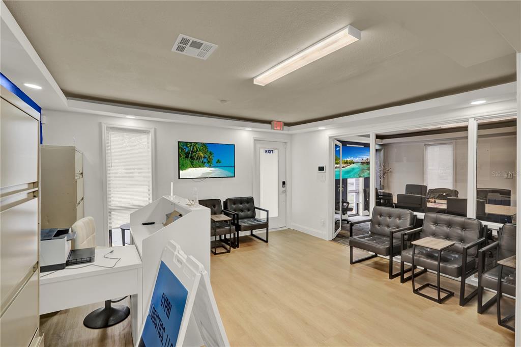 A bright office reception area features light wood flooring, white walls, and black leather chairs — 750 LOWELL BOULEVARD, ORLANDO, FL