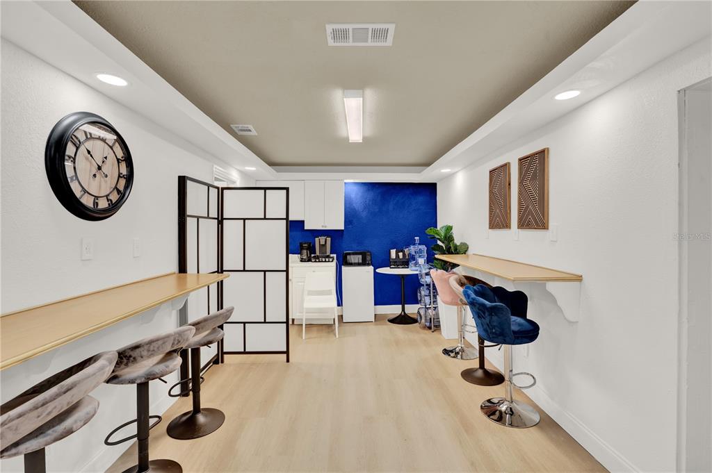 A room features two long wall-mounted desks with bar stools and a blue accent wall — 750 LOWELL BOULEVARD, ORLANDO, FL