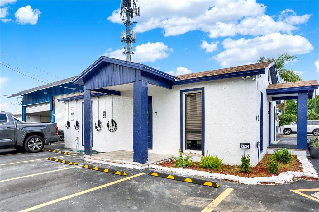 A white building with blue trim and a covered entrance stands in a parking lot — 750 LOWELL BOULEVARD, ORLANDO, FL