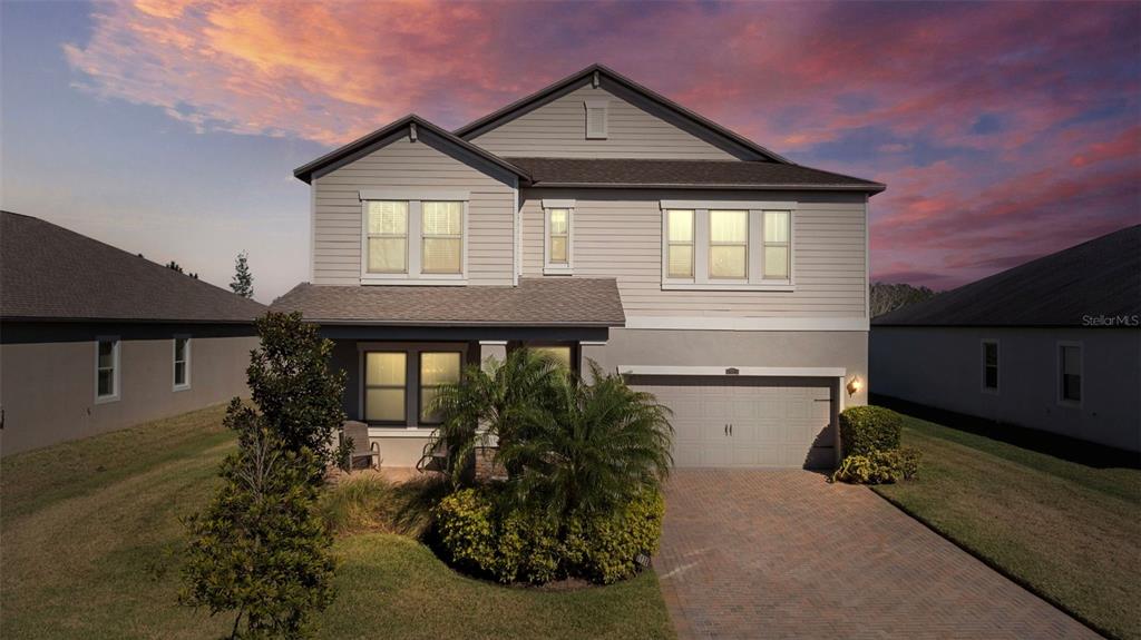 A two-story suburban house with a paved driveway, a garage, and a small front porch — 3138 HILLIARD DRIVE, WESLEY CHAPEL, FL