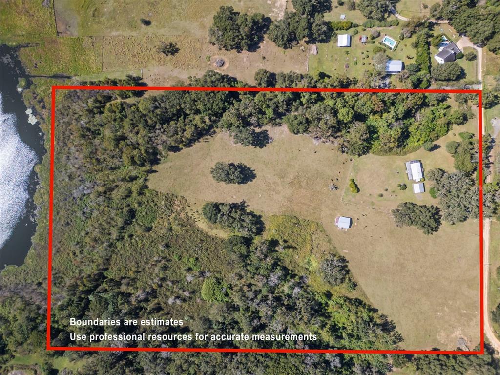 An aerial view shows a rural property with a house, outbuildings, trees, and a lake — 32854 LISTER ROAD, DADE CITY, FL