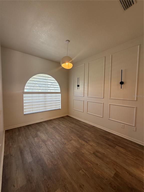 A room with wood-look flooring, a large arched window, and decorative wall molding — 2210 TOWERING OAKS CIRCLE, SEFFNER, FL