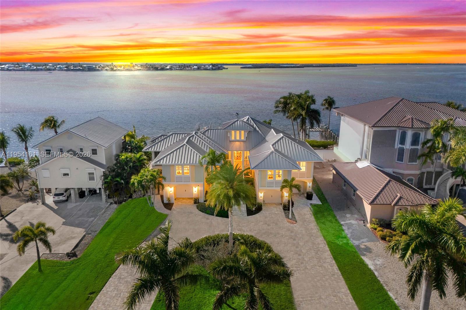 Curb appeal alert! Large circular paved driveway welcomes you to this STUNNING 3 bedrooms and a den, 5 bathrooms, and split 4 car garage! Endless views of sunsets and a dream waterfront lot! — CAPE CORAL, FL