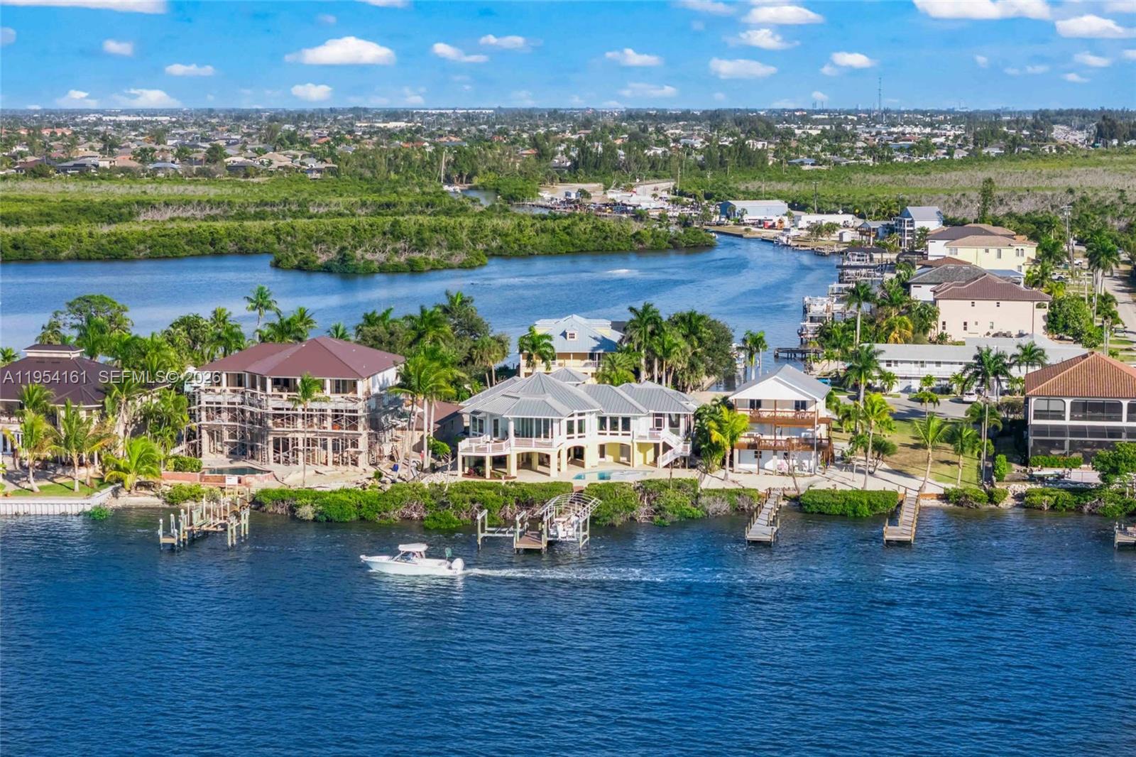 Back of home featuring extensive outdoor patios and living space and a sparkling pool and spa! — CAPE CORAL, FL