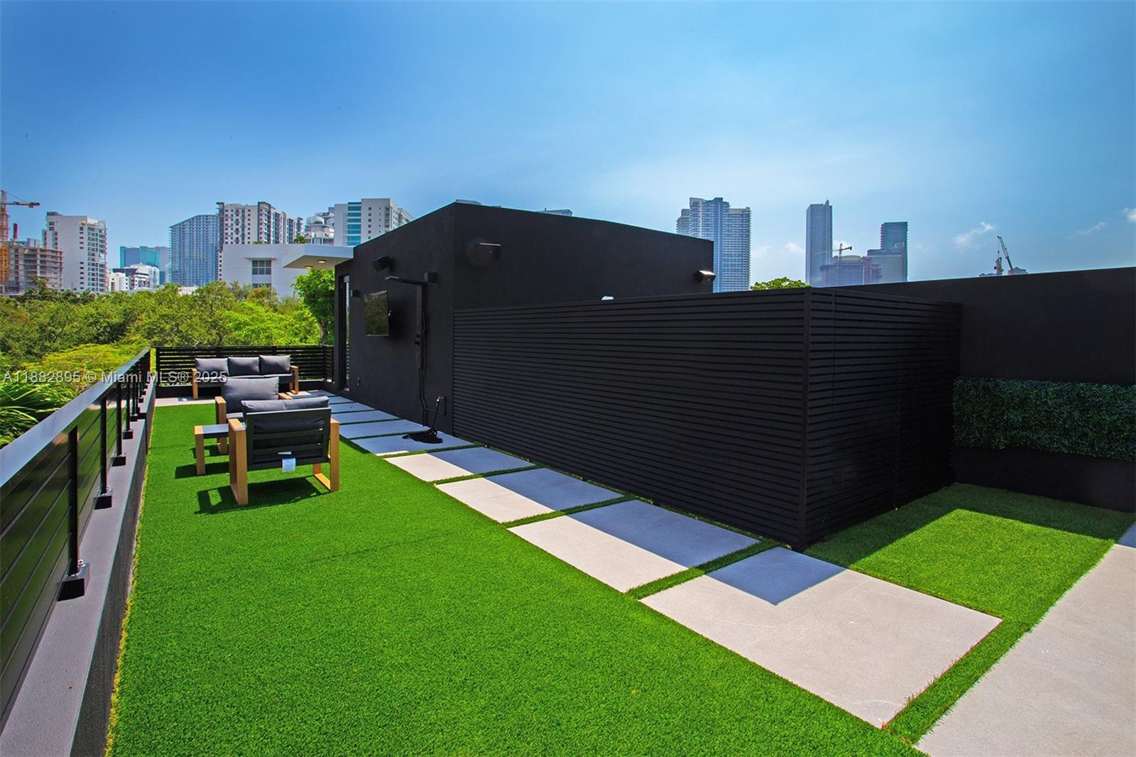 A rooftop terrace features artificial turf, concrete pavers, modern seating, and a black privacy wall — 420 SW 15th Rd, Miami FL 33129, MIAMI, FL