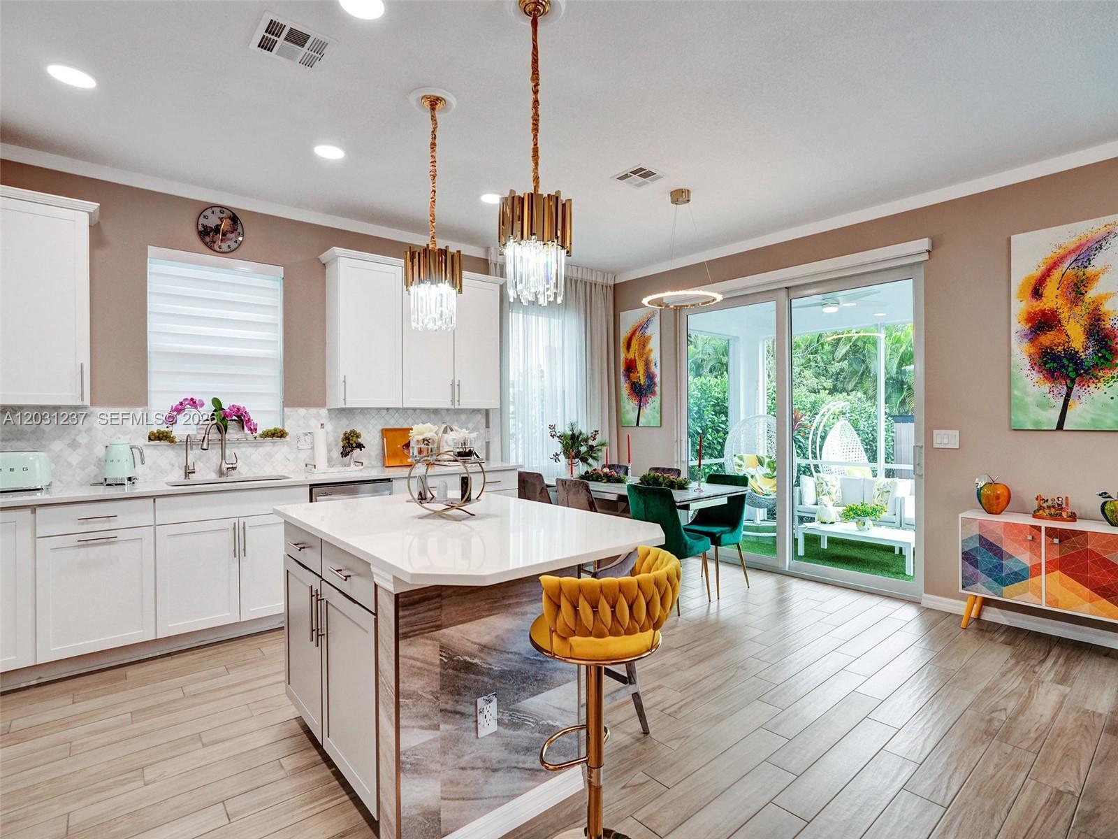 A modern kitchen features a white island with a marble-patterned side and gold bar stools — 4414 Ficus St, Hollywood FL 33021, HOLLYWOOD, FL
