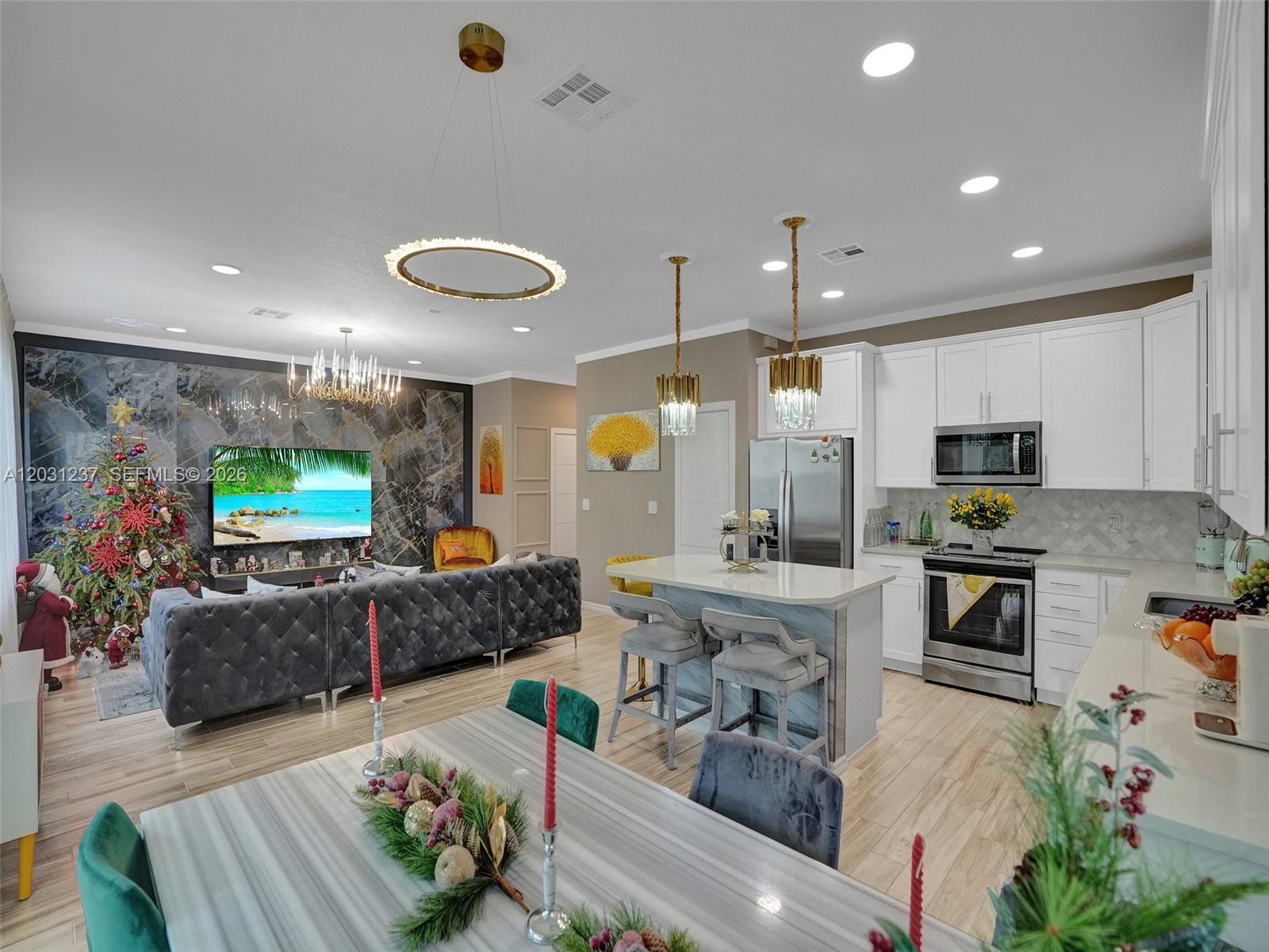 An open-concept kitchen and living area features a marble accent wall and white cabinetry — 4414 Ficus St, Hollywood FL 33021, HOLLYWOOD, FL