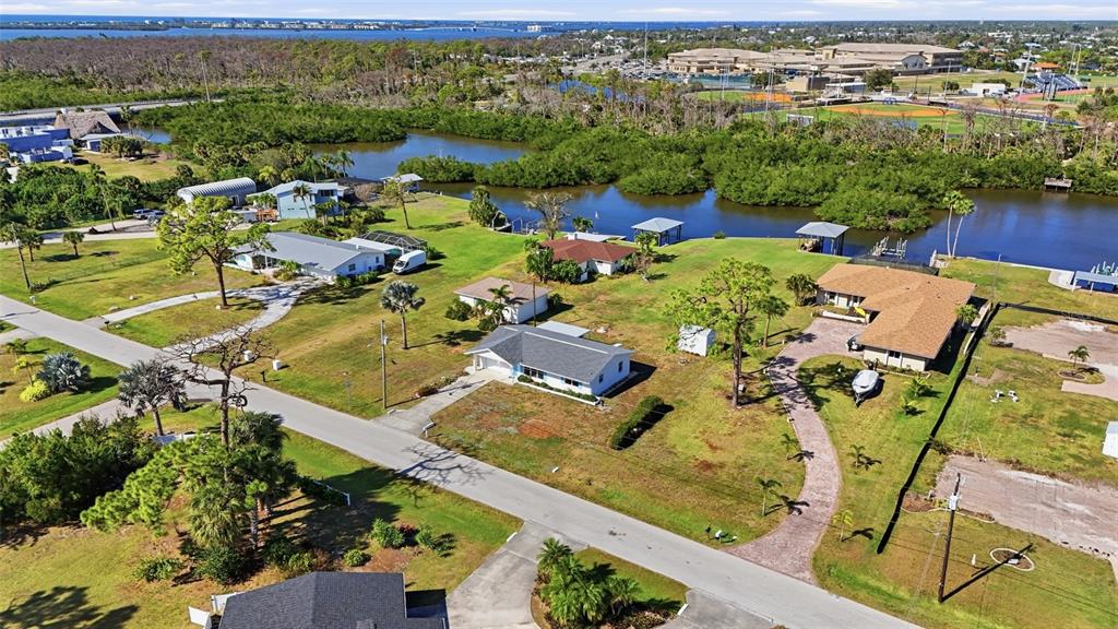 An aerial view shows several houses with driveways and lawns near a coastal waterway — 2050 OYSTER CREEK DRIVE, ENGLEWOOD, FL