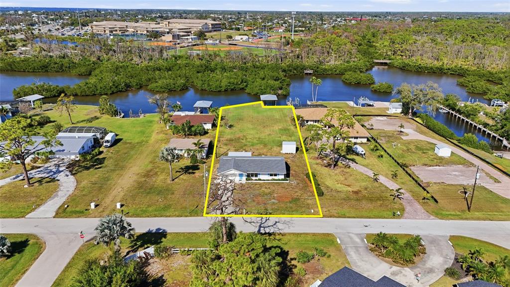 An aerial view shows a single-story house on a waterfront lot outlined in yellow — 2050 OYSTER CREEK DRIVE, ENGLEWOOD, FL
