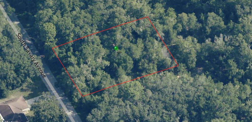 An aerial view shows a rectangular, wooded plot of land adjacent to a paved road — 3708 E FAIR COURT, INVERNESS, FL