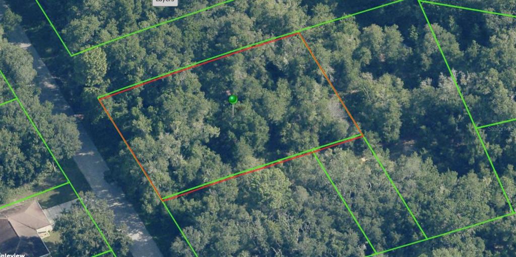 An aerial view shows a wooded, rectangular plot of land outlined in red and green — 3708 E FAIR COURT, INVERNESS, FL