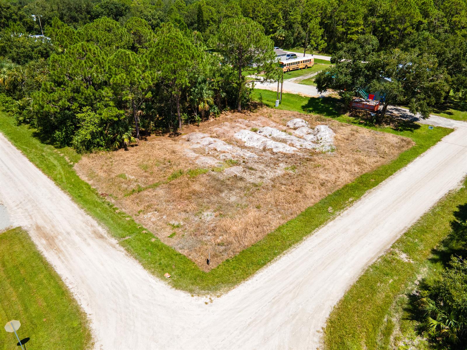 An aerial view shows a vacant, grassy corner lot bordered by two dirt roads — 9216 103rd Court, Vero Beach FL 32967, VERO BEACH, FL