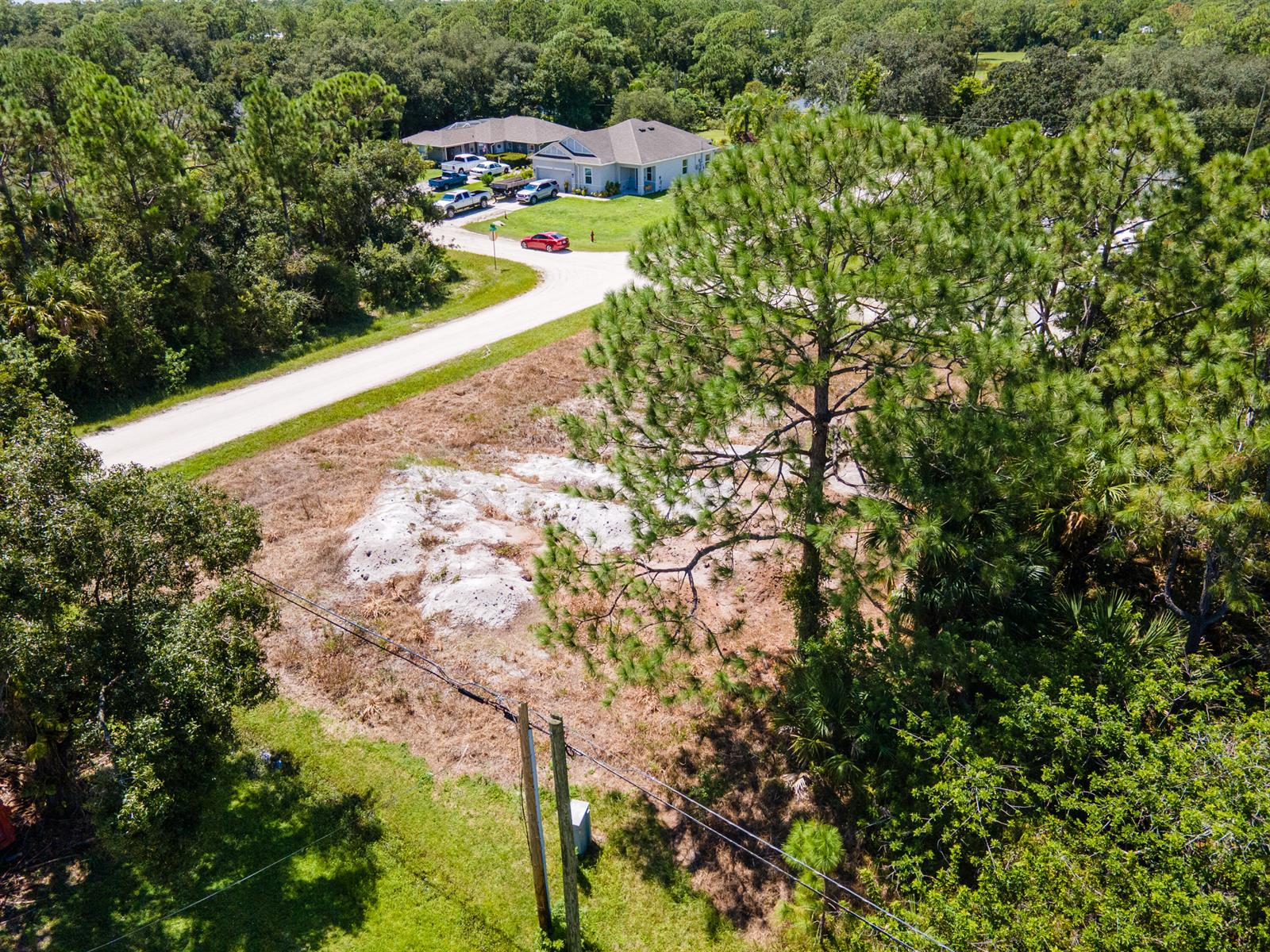 An aerial view shows a vacant, partially cleared lot with a large pine tree — 9216 103rd Court, Vero Beach FL 32967, VERO BEACH, FL