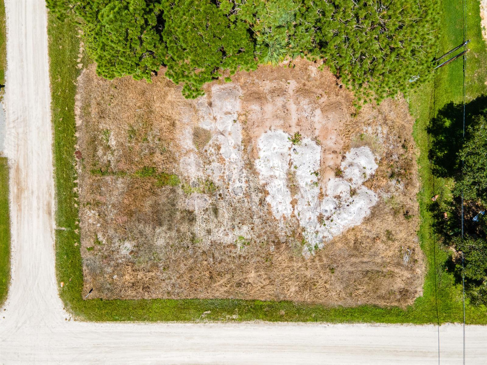 An aerial view of a rectangular, cleared dirt lot bordered by trees and dirt roads — 9216 103rd Court, Vero Beach FL 32967, VERO BEACH, FL