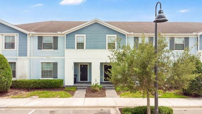 A two-story blue and white townhouse exterior with a sidewalk and street lamp — 8904 SYDNEY AVENUE, KISSIMMEE, FL