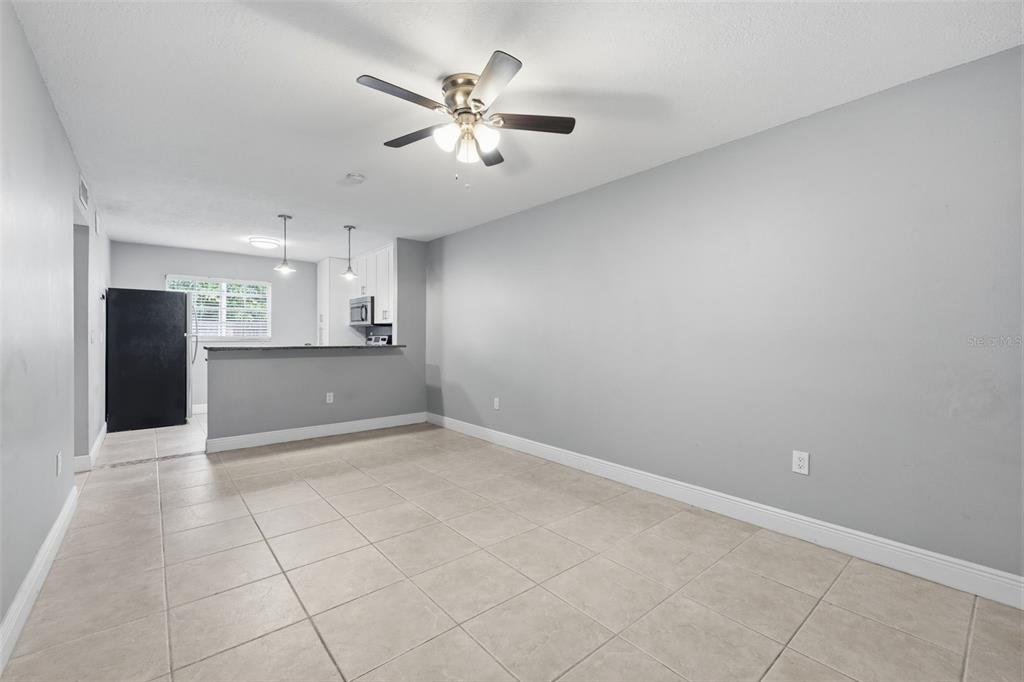 A dining area with tile flooring, a ceiling fan, and an open kitchen with a counter — 2207 S CAROLINA AVENUE UNIT 9, TAMPA, FL