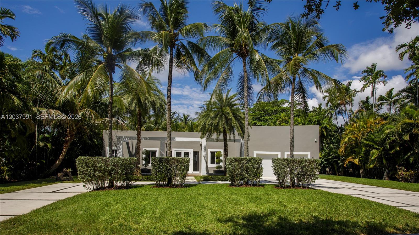A modern, single-story house with a flat roof is surrounded by palm trees and landscaping — 11900 Griffing Blvd, Biscayne Park FL 33161, BISCAYNE PARK, FL