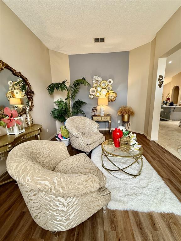 A living room features two patterned armchairs, a glass coffee table, and a gray accent wall — 1748 FLORENCE VISTA BOULEVARD, ORLANDO, FL