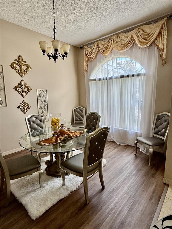 A dining room features a glass-topped table, tufted chairs, a chandelier, and a large window — 1748 FLORENCE VISTA BOULEVARD, ORLANDO, FL