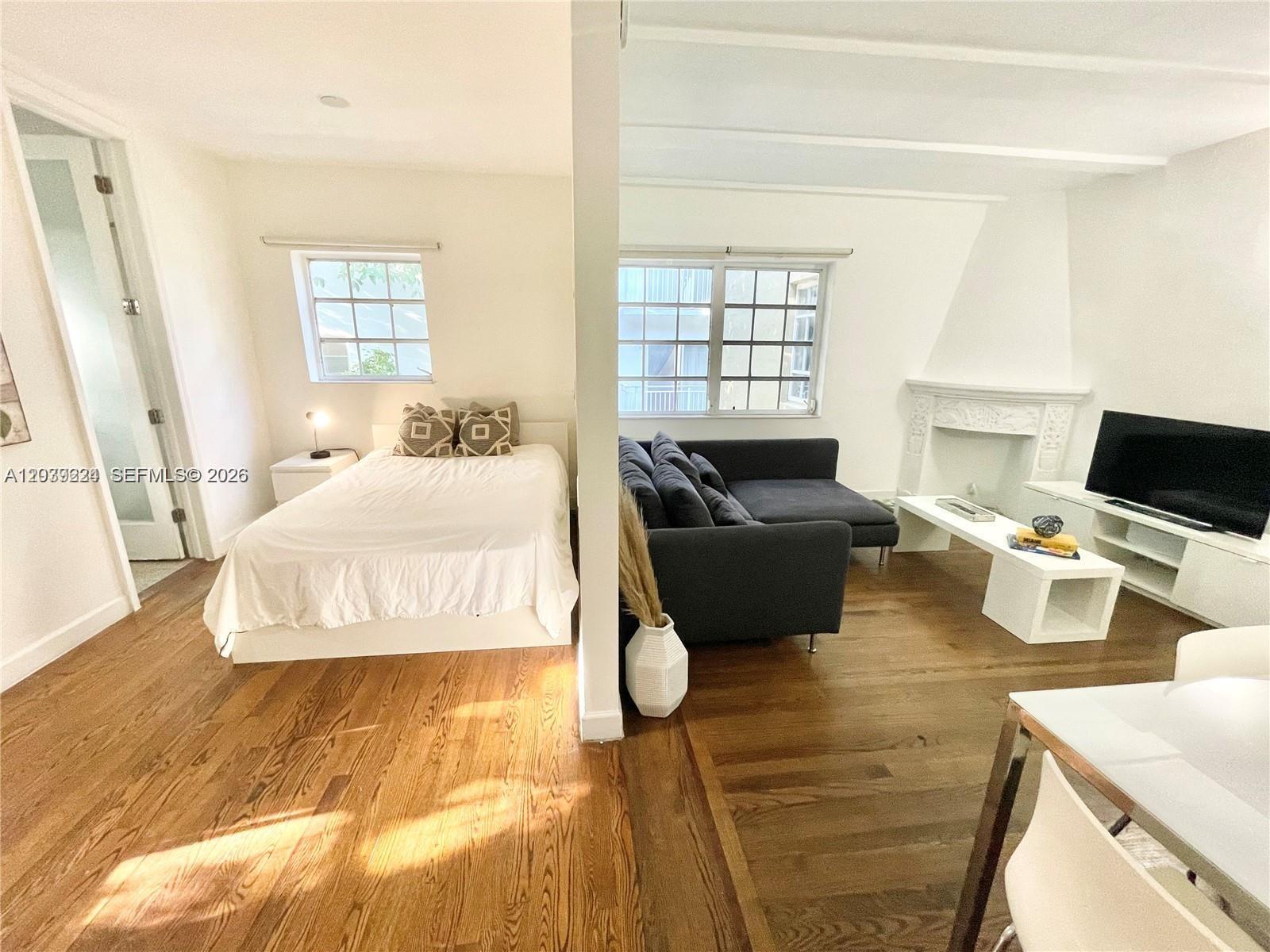 A studio apartment features a bedroom area, a living room with a sofa, and hardwood floors — 439 15th St # 18, Miami Beach FL 33139, MIAMI BEACH, FL
