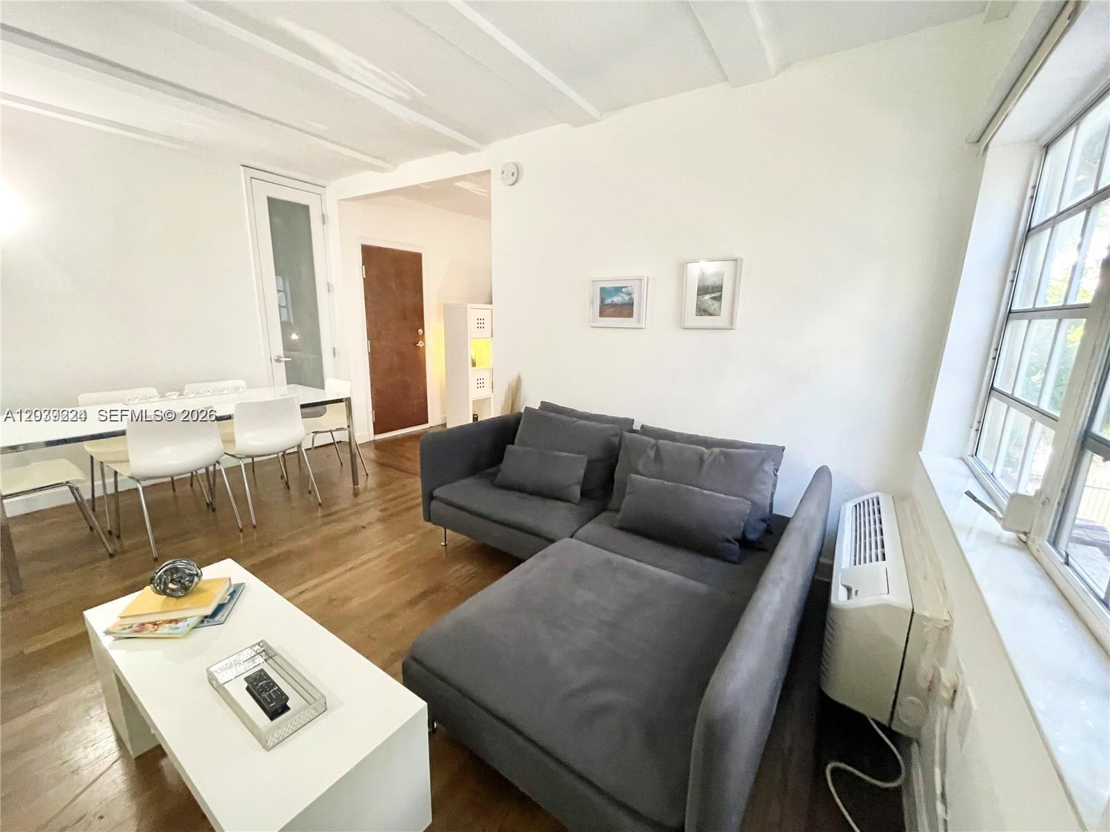 A living room features a gray sectional sofa, a white coffee table, and dining furniture — 439 15th St # 18, Miami Beach FL 33139, MIAMI BEACH, FL