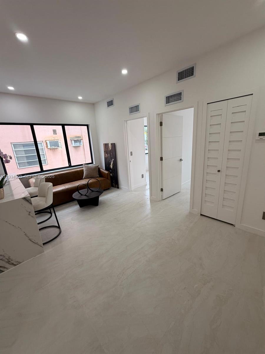 A living room features a brown leather sofa, white tile floors, and two interior doors — 2436 SW 7th St # 6, Miami FL 33135, MIAMI, FL