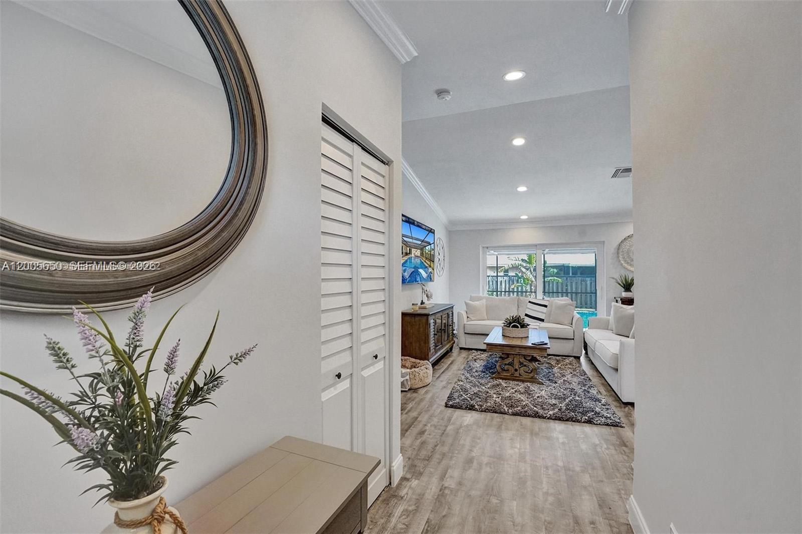 A view from a hallway into a living room with light flooring and white furniture — 6549 Sleepy Willow Way # 6549, Delray Beach FL 33484, DELRAY BEACH, FL