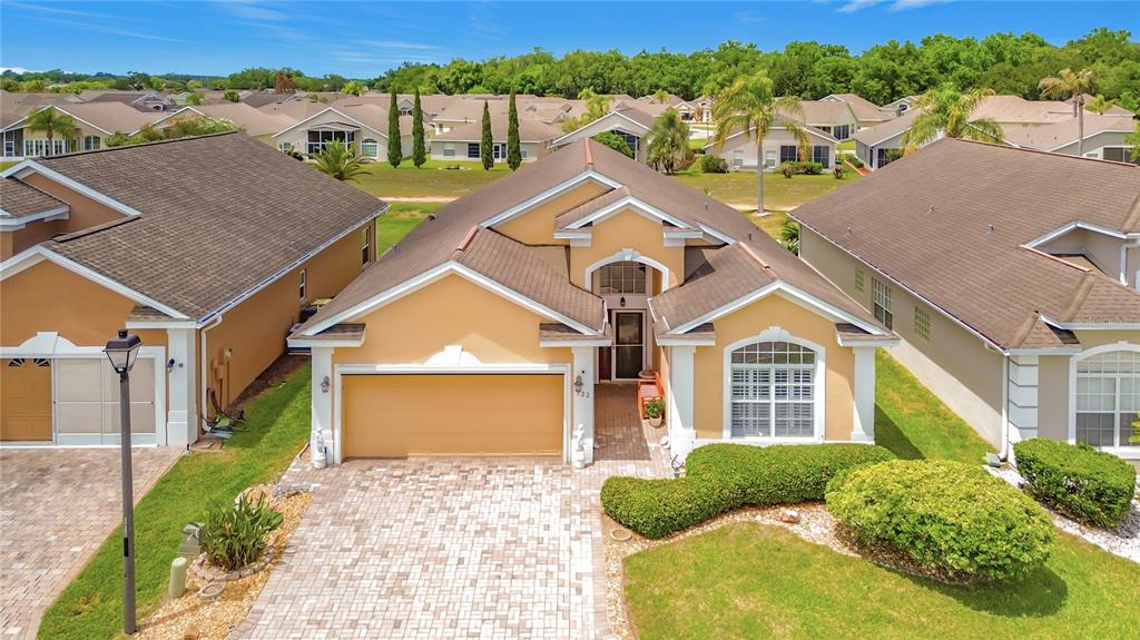 An exterior view of a tan, single-story suburban house with a paved driveway and lawn — 322 HIGH VISTA DRIVE, DAVENPORT, FL