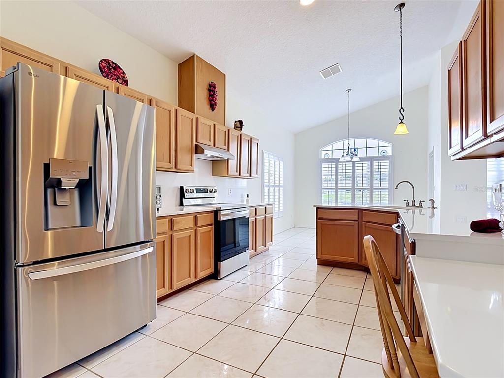 A kitchen with light wood cabinets, stainless steel appliances, and tile flooring — 322 HIGH VISTA DRIVE, DAVENPORT, FL