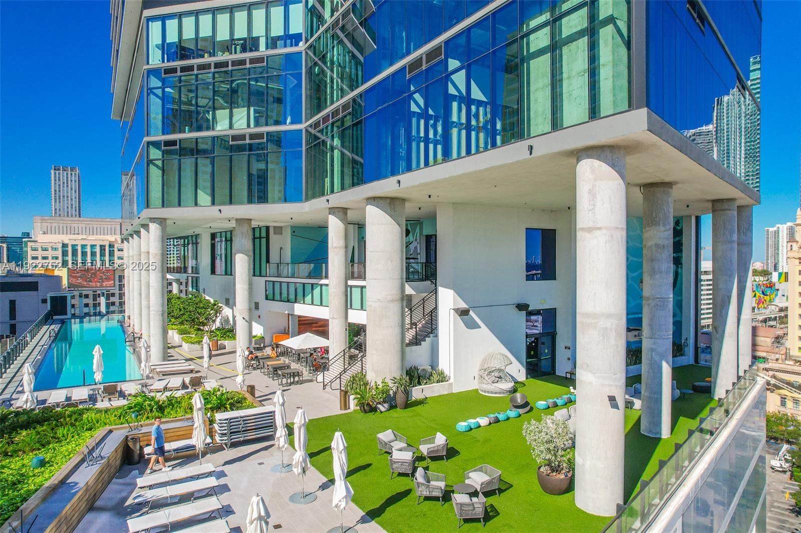 An outdoor pool deck features lounge chairs, artificial turf, and large concrete support columns — 398 NE 5th St # 2319, Miami FL 33132, MIAMI, FL