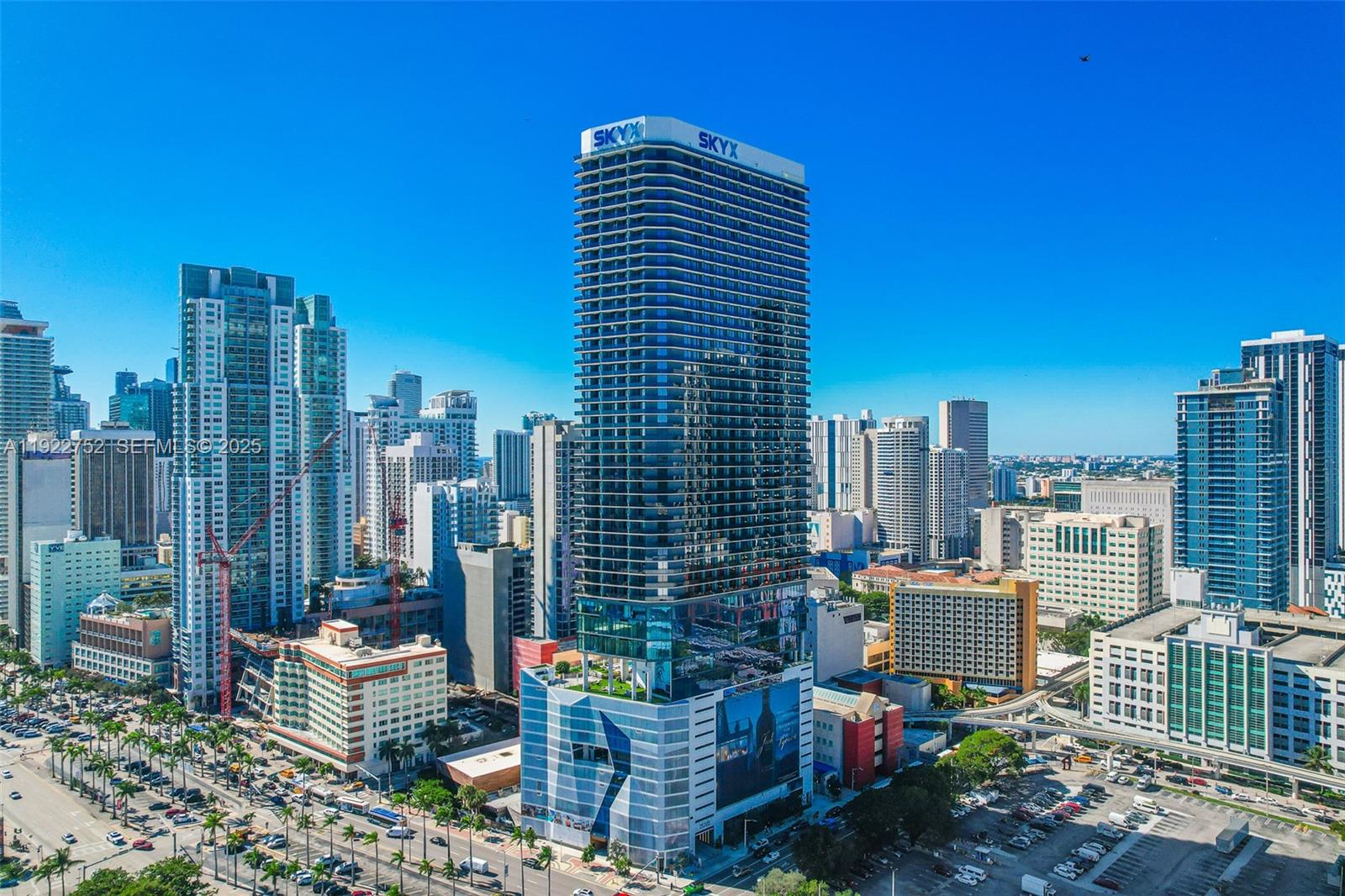 An aerial view shows a tall, modern glass skyscraper with the name SKYX on top — 398 NE 5th St # 2319, Miami FL 33132, MIAMI, FL