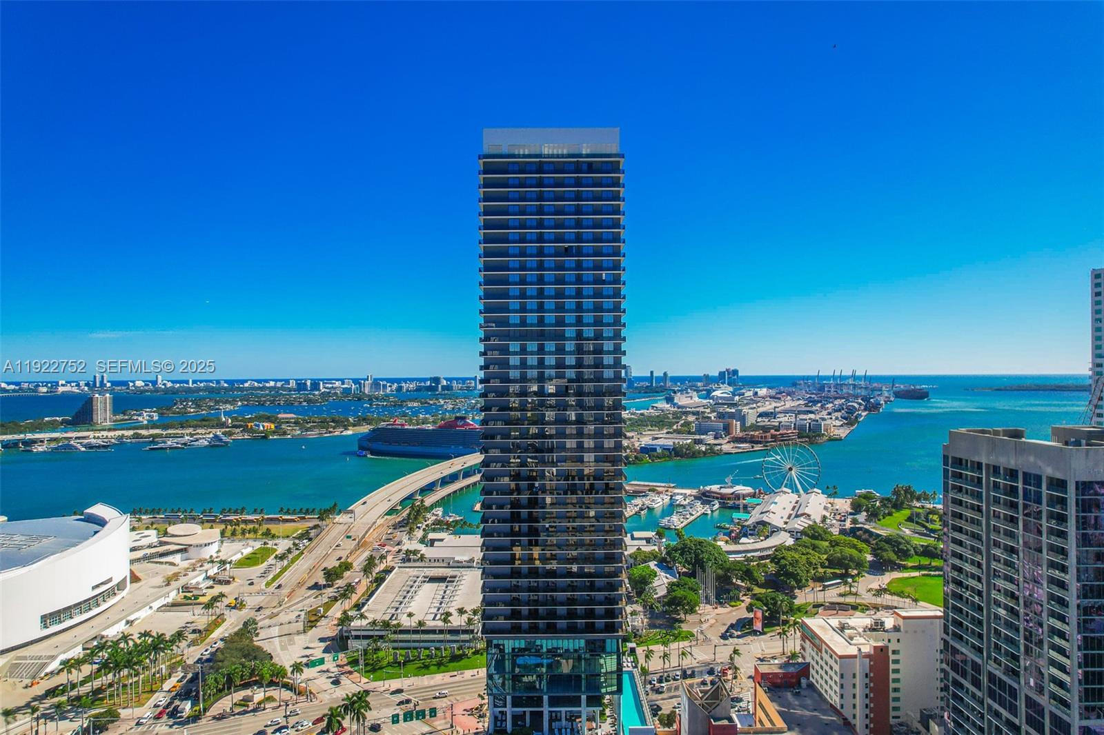 An aerial view shows a tall, modern residential skyscraper overlooking a bay and city — 398 NE 5th St # 2319, Miami FL 33132, MIAMI, FL