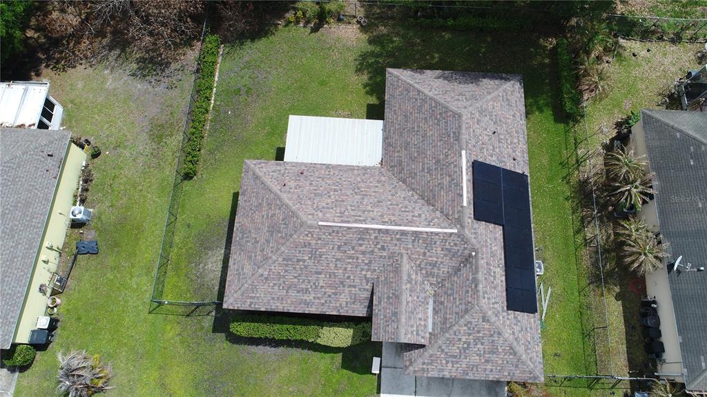 An aerial view shows a house with a shingled roof and installed solar panels — 782 MINK COURT, KISSIMMEE, FL