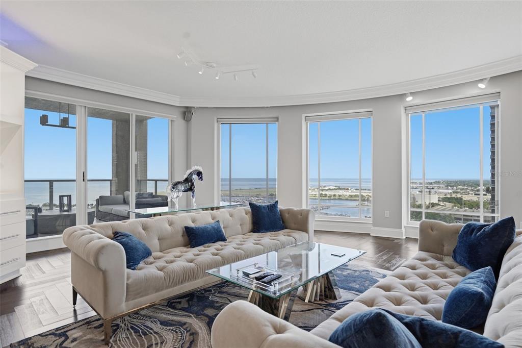 A room with dark wood floors, large windows, and a balcony overlooking a marina — 100 BEACH DRIVE NE UNIT 1900, ST PETERSBURG, FL