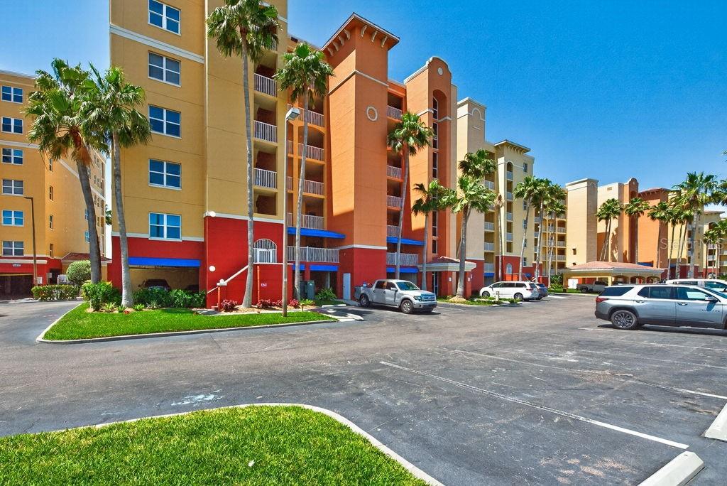 A multi-story apartment complex with colorful exterior walls and palm trees in a parking lot — 16500 GULF BOULEVARD UNIT 654, NORTH REDINGTON BEACH, FL