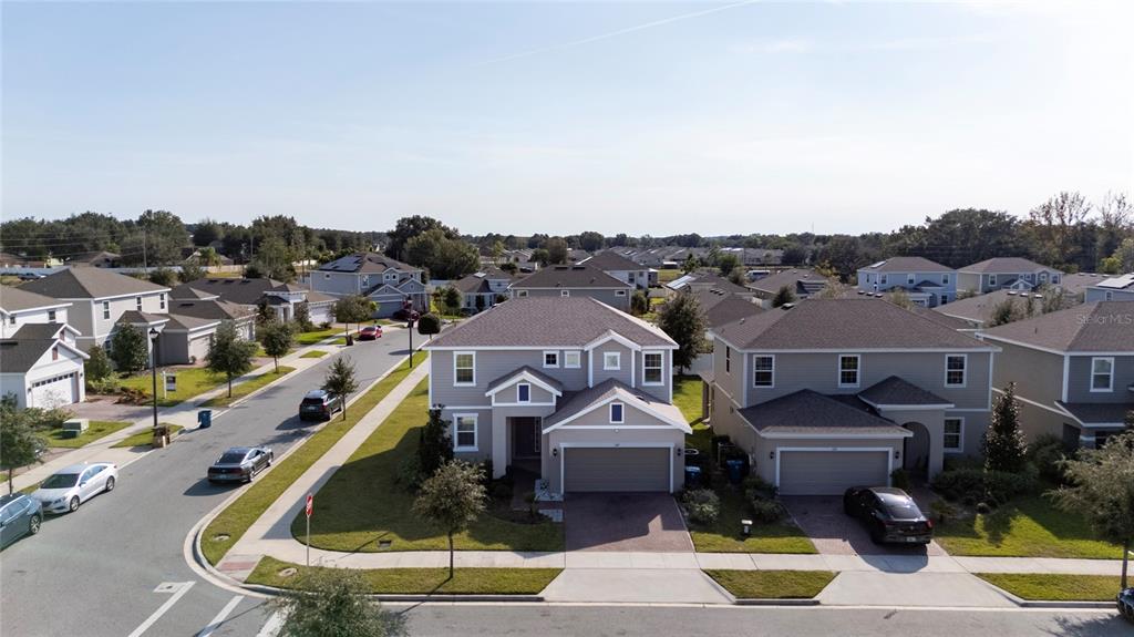 An aerial view shows suburban houses with gray roofs and driveways along a paved street — 1369 YORKDALE ROAD, DAVENPORT, FL