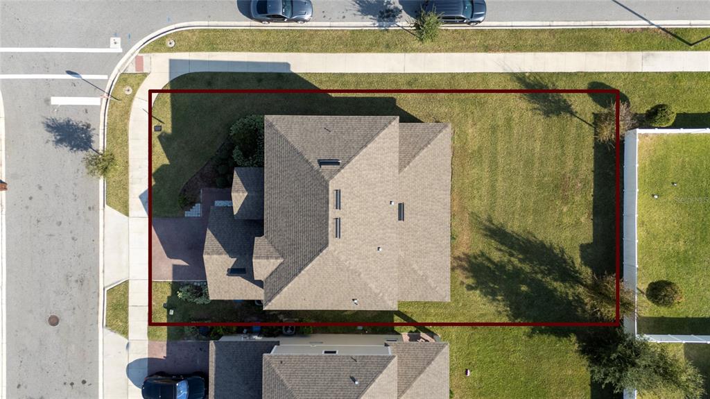 An aerial view shows a house with a shingled roof on a corner lot — 1369 YORKDALE ROAD, DAVENPORT, FL