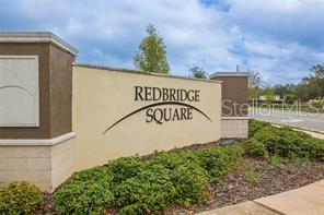 A tan monument sign for Redbridge Square stands in front of landscaping under a cloudy sky — 1369 YORKDALE ROAD, DAVENPORT, FL