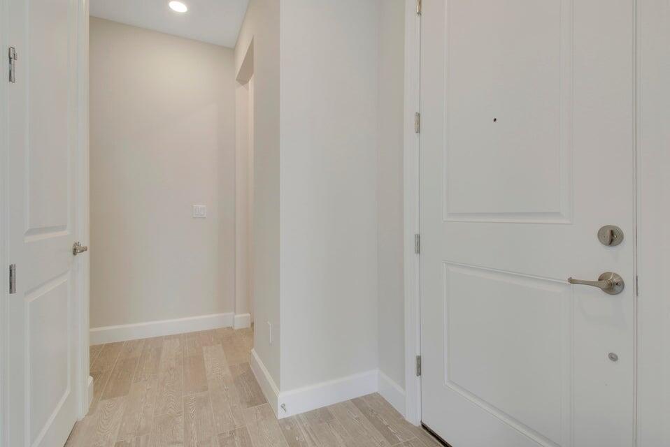 A bright entryway features light wood-look tile flooring, white walls, and two white interior doors — 1875 SE Ocean Cove Way, Stuart FL 34996, STUART, FL