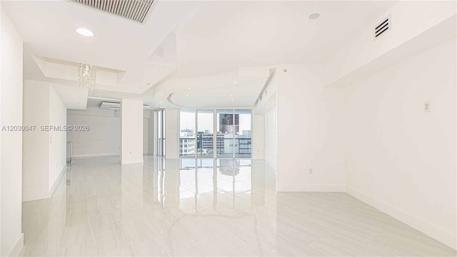 A bright, open-concept living area features white tile floors, recessed lighting, and floor-to-ceiling windows — FORT LAUDERDALE, FL