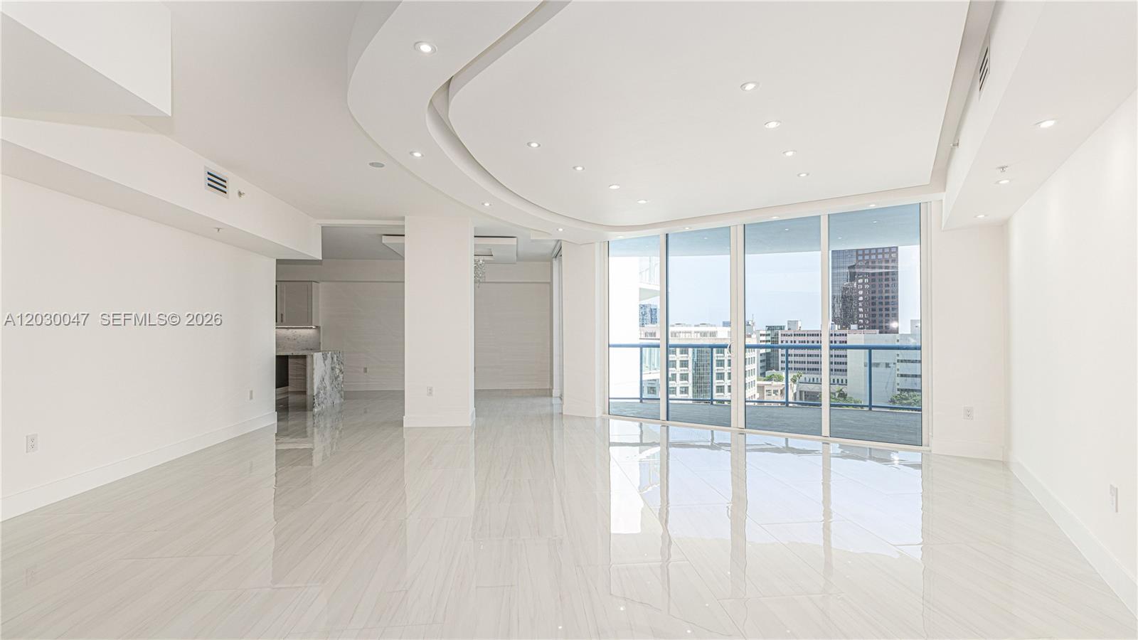 A bright, open-concept living room features white tile floors, recessed lighting, and floor-to-ceiling windows — FORT LAUDERDALE, FL