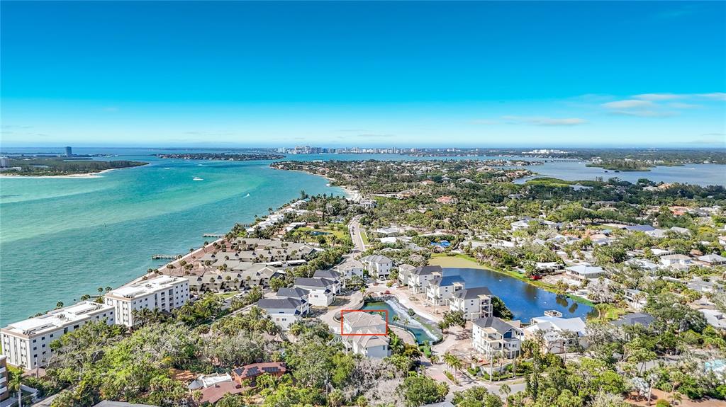 An aerial view shows a coastal residential area with a highlighted house near a pond — 6925 BOCHI CIRCLE, SARASOTA, FL