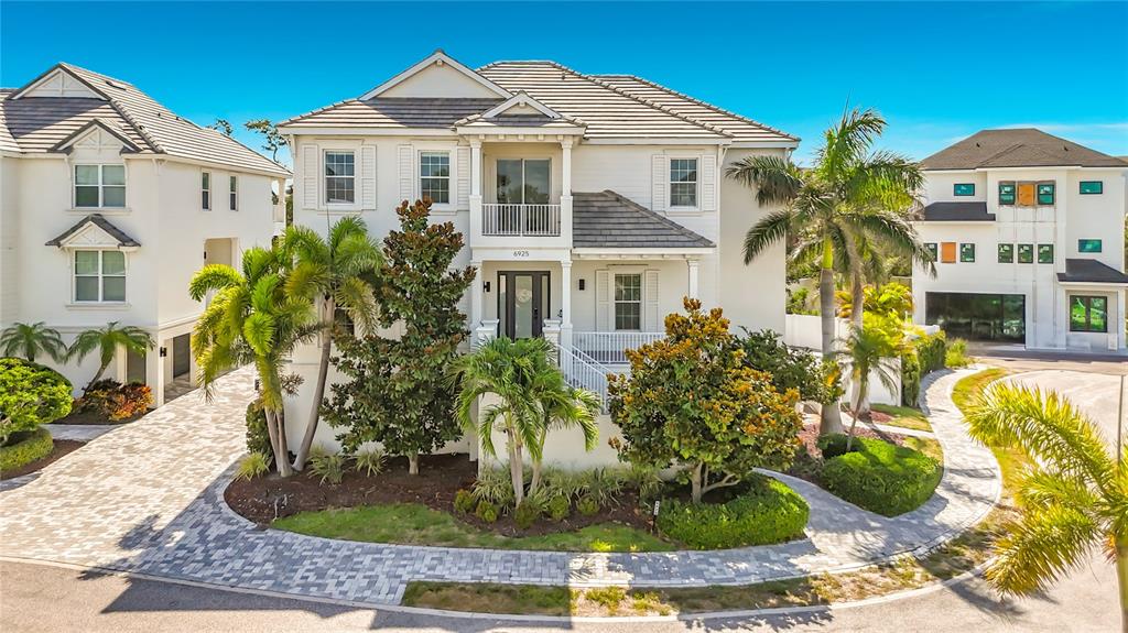 A two-story white house with a tiled roof, palm trees, and a paved driveway — 6925 BOCHI CIRCLE, SARASOTA, FL
