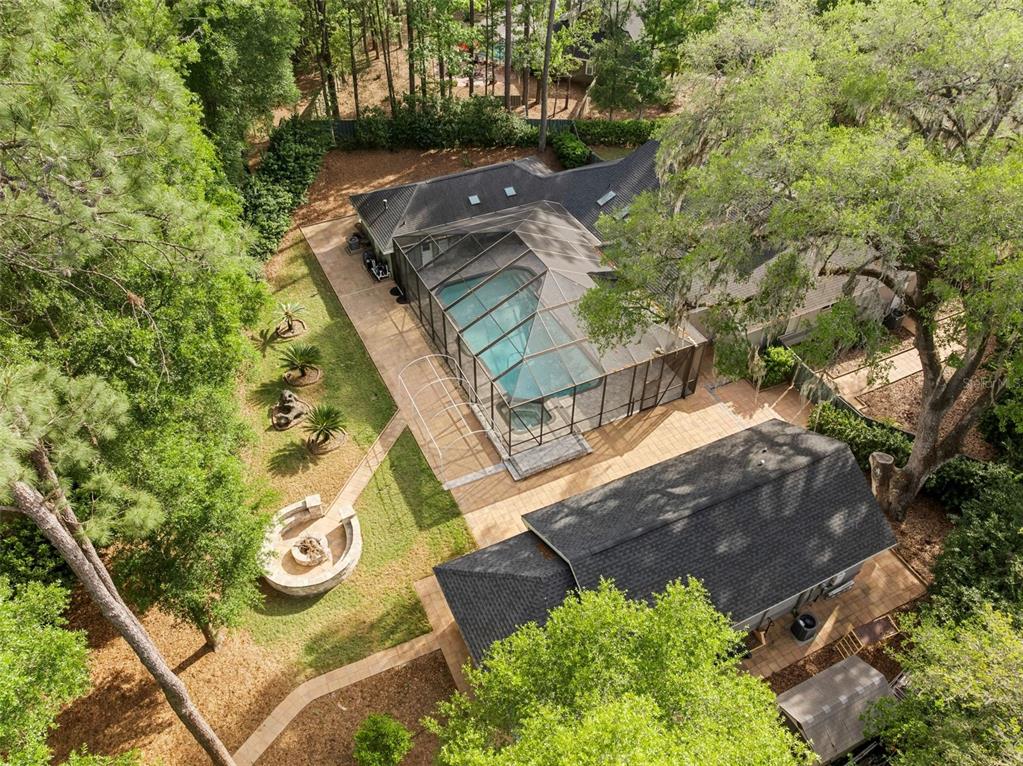 An aerial view of a house with a screened-in pool, patio, and backyard fire pit — 8701 SW 46TH LANE, GAINESVILLE, FL