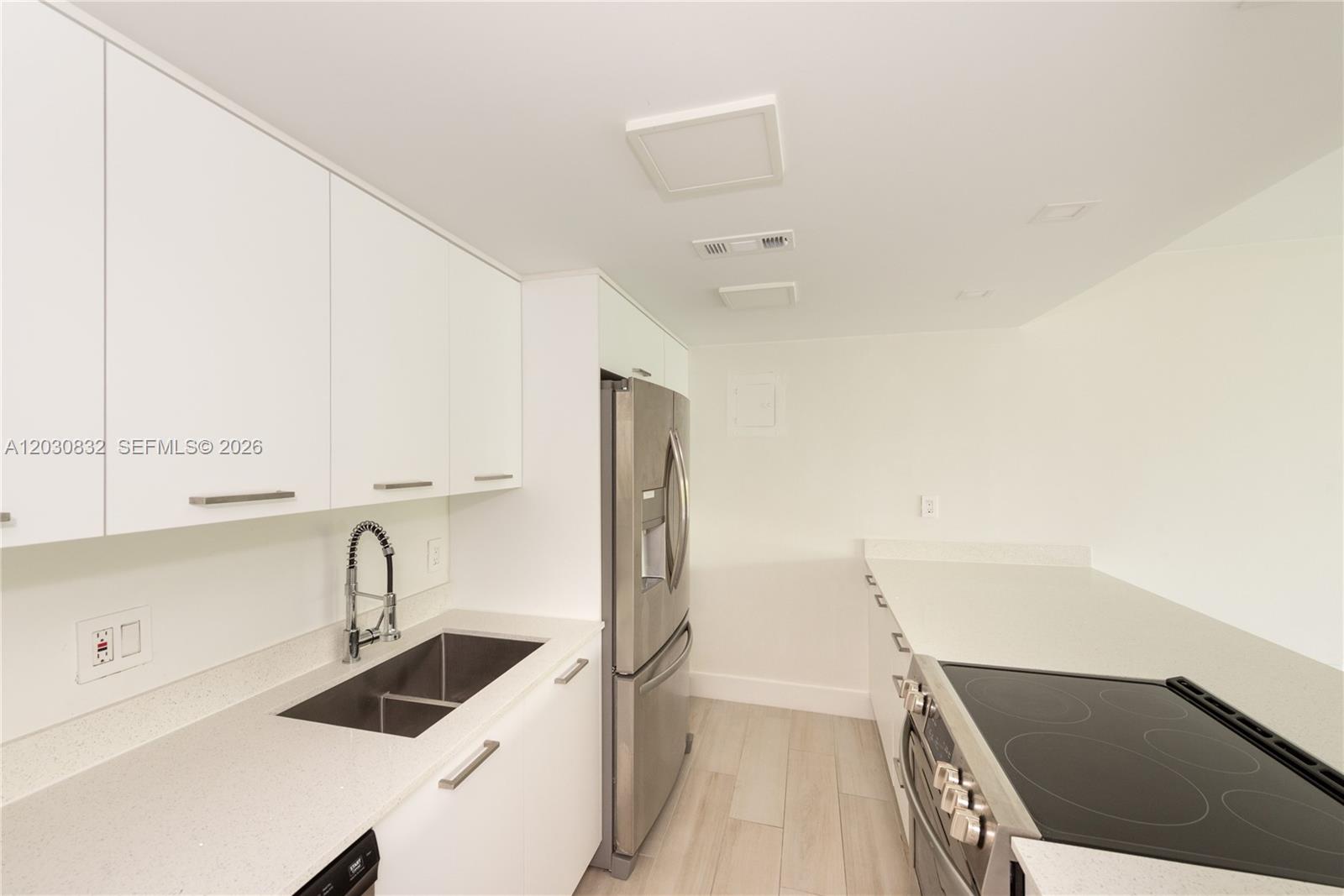 A modern kitchen features white cabinets, stainless steel appliances, and light-colored countertops — 155 Ocean Lane Dr # 403, Key Biscayne FL 33149, KEY BISCAYNE, FL