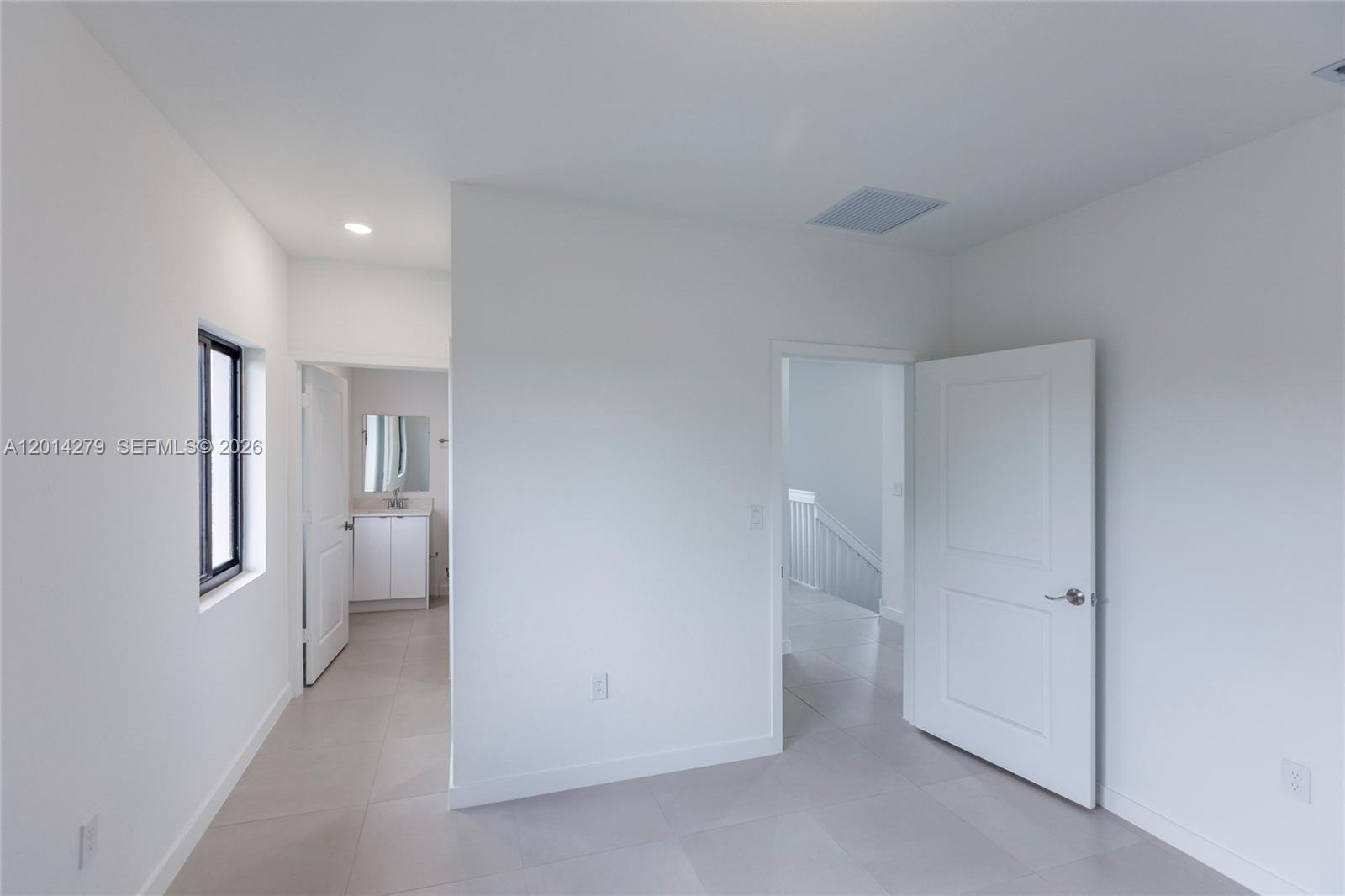 A bright, minimalist room features white walls, tile flooring, and two open doorways — 9151 NW 32 Ave, Miami FL 33147, MIAMI, FL