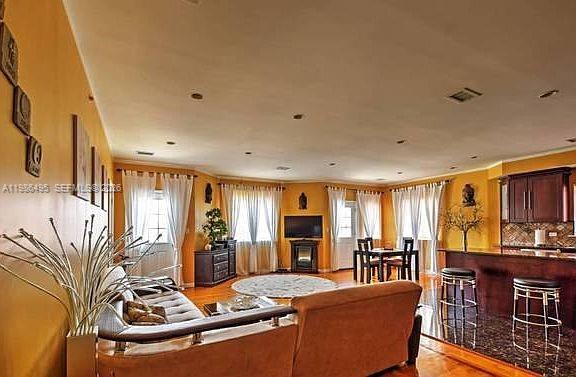 A living room with a sofa, dining area, and kitchen island with bar stools — 2841 Ford # 2, NY 11235, NY