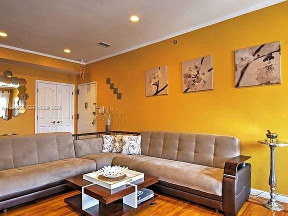 A living room features a tan sectional sofa, a wooden coffee table, and yellow walls — 2841 Ford # 2, NY 11235, NY