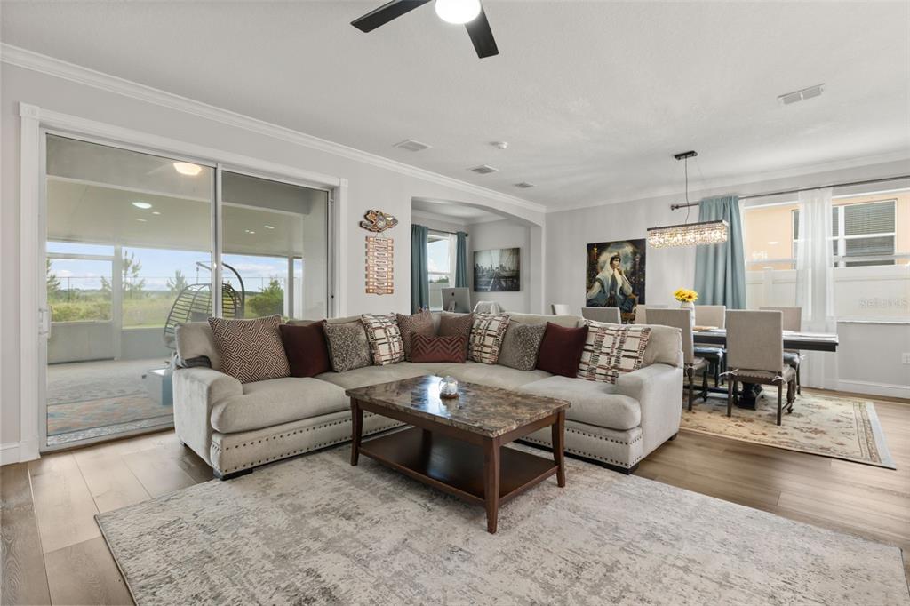 A living room features a large sectional sofa, a coffee table, and an adjacent dining area — 268 JYOTI DRIVE, DAVENPORT, FL